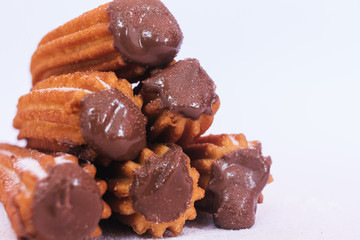 Churros stuffed with chocolate sauce on white background