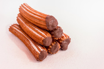 Churros stuffed with chocolate sauce on white background