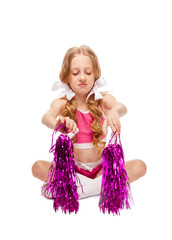 girl in the form of a cheerleader looks at pom poms as if she is unpleasant