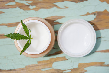 Cannabis cream with marijuana leaf in jar. Concept of herbal alternative medicine, cbd oil, pharmaceptical industry, cannabis cosmetics