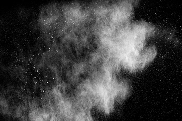 Bizarre forms of  white powder explosion cloud against dark background. Launched white particle splash on black background