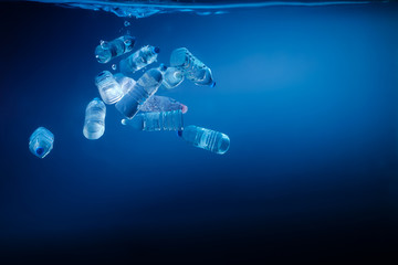 Obraz na płótnie Canvas Plastic bottles sinking in to the ocean. Enviromental polution concept. World ocaens day