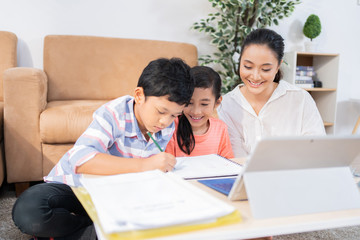 Son and daughter studying online His mother helped teach homework.