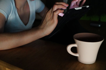 Woman playing ipad at night
