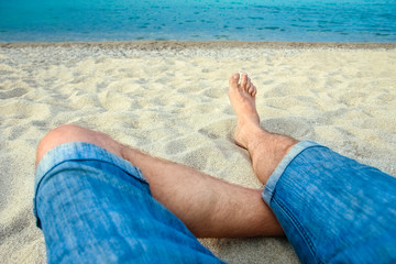 beautiful legs in the sand of the sea greece background