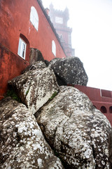 Large beautiful stones on a background of red medieval buildings and defocused tower in the fog