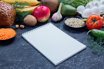 Diet food menu with fruits, vegetables and seeds on a black stone background