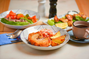 Salad with meat and vegetables. Italian cuisine, different dishes served in restaurant on light rustic wooden table.