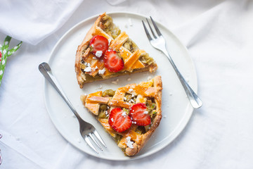 Slices of strawberry and rhubarb pie on white plate. Top view. Homemade summer bakery.