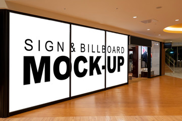 Mock up blank billboard on glassy showcase in shopping mall