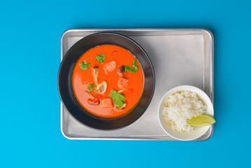 Fresh tomato soup with mushrooms and chicken meat in a black bowl. Tasty dinner.
