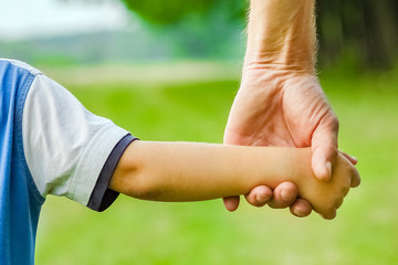 beautiful hands of parent and child outdoors in the park