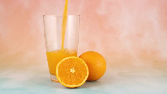Pouring fresh squeezed orange juice in glass 