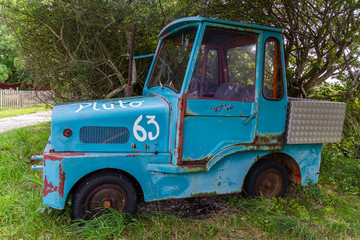 An old abandoned blue two-places car in the village