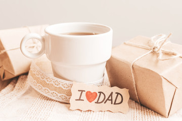 Gift box with a tag, cup of coffee or tea. Father's day or birthday concept.