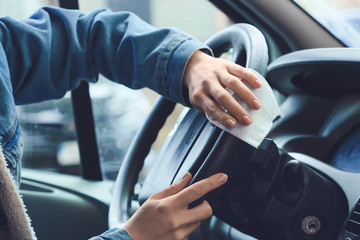 Woman disinfecting salon of car