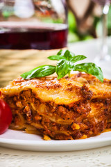 Piece of tasty hot lasagna with red wine..