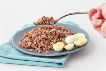 Buckwheat porridge on a plate with quail eggs and two slices of butter. Healthy food concept. Copy space.