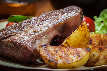 Portions of grilled beef steak with grilled potatoes and paprika