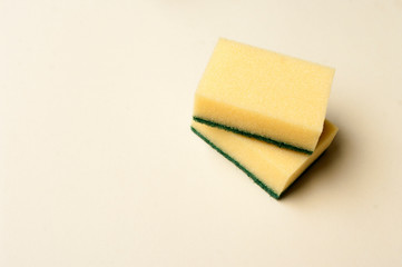 Two yellow sponges on light background. Copy space for text. Concept cleaning and housekeeping.