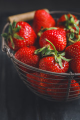 Basket with ripe strawberry on dark background, closeup