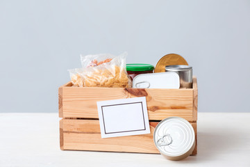 Box with donations on table against light background