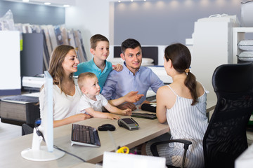 Happy family choosing fabric for upholstery mattress in salon