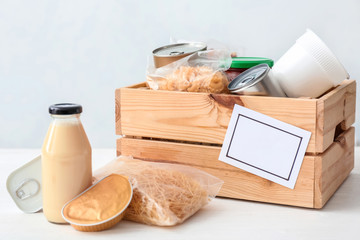Box with donations on table against light background