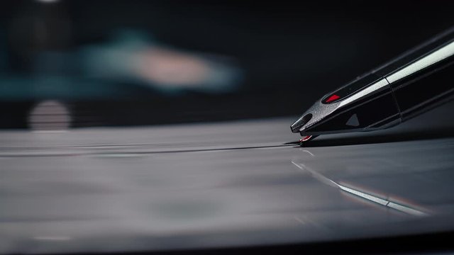 Macro shot of a record player's needle on a spinning vinyl record.