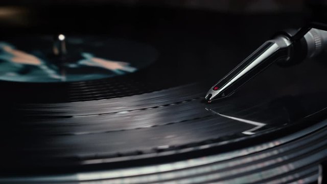 Close-up of a vinyl record spinning on a turntable with the needle in frame.