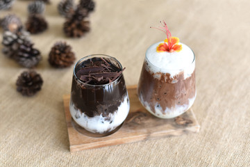 tasty cocoa drink with chocolate dessert bar. Summer refreshment drinks. Chilled iced chocolate cocoa on Sackcloth with Pine cones. top view and Selected focus.