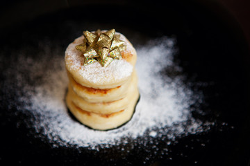 Special holiday cheesecakes stack decorated with festive golden bow on top 