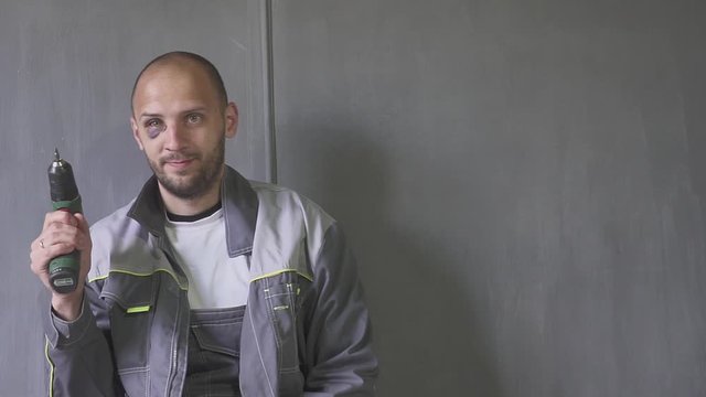 Man with a black eye with a screwdriver in hand