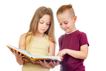 Young smiling cute girl and boy are looking at the yellow book isolated on white background - 353064773