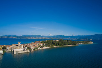 Fototapeta na wymiar Panoramic aerial view of the Sirmione peninsula, Lake Garda Italy. Rocca Scaligera Castle. The village where Catullo lived.
