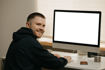 Remote work. A businessman works remotely using an all-in-one computer. A smiling fellow working from home.