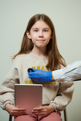 A hand of a physician holds a stethoscope hearing the heartbeat of a young female patient. A happy...