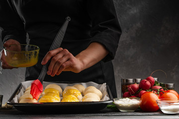 Cooking baker rolls on the background of ingredients and vegetables. Tasty and wholesome food, restaurant business, recipe book. Space for a banner