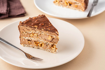 Chocolate cake with nuts and caramel on a light background.
