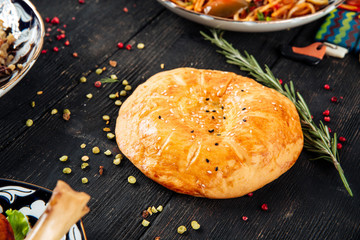 Uzbek flat cake lepeshka on the dark wooden table