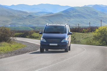 Minivan moves along a winding road in the mountains