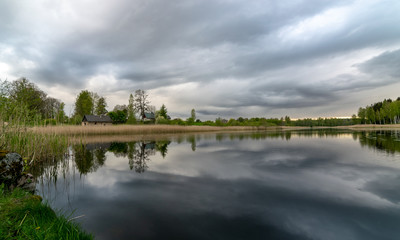 Fototapeta na wymiar spring landscape with beautiful sky, clouds and tree reflections in the water