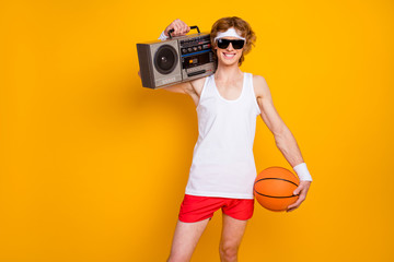 Portrait of his he nice funky cheerful cheery glad guy holding in hands carrying boombox orange...