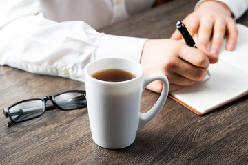 Man making notes with pen in notebook