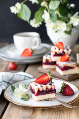 piece of tasty pie with strawberries on a white plate on ooden table