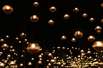 blur bokeh circus tube lamp hang from ceiling in dark room like firefly 