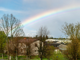 colorful landscape with a rainbow over the trees, a small village view