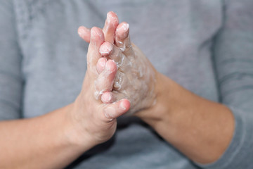 A woman applying nourishing cream in her hands