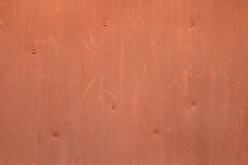 The wall is red orange with scratches and scuffs. Painted iron sheet nailed. The background for text and design. Image for the backdrop and wallpaper.