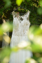 White wedding dress hanging on a tree